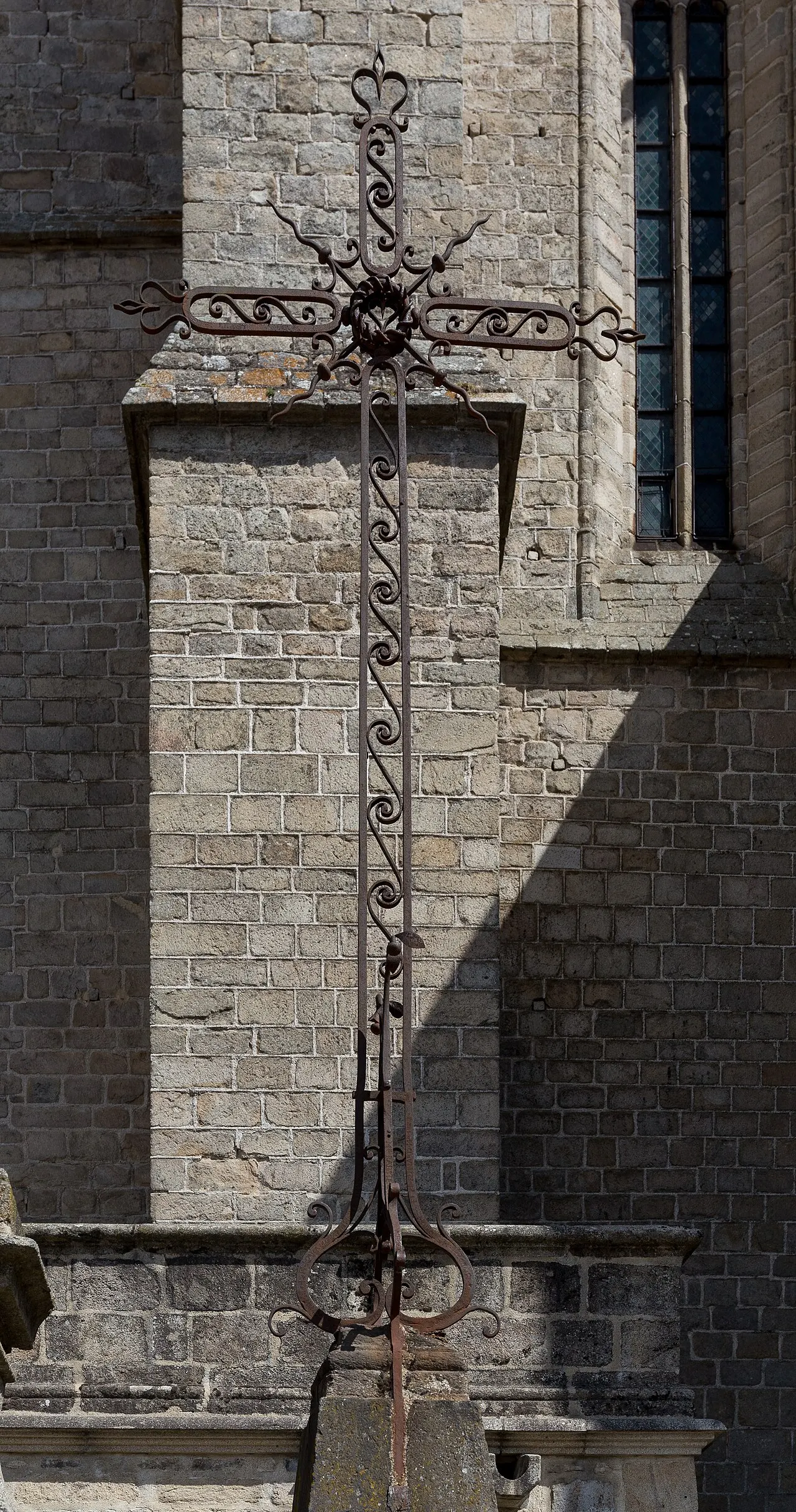 Croix en fer forgé à droite de l’escalier devant l’église